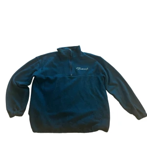 Mörkgrön Halfzip Fleecetröja Retro - Säljer en mörkgrön fleece tröja från Leaves i bra skick. Den har en halv dragkedja framtill och elastiska muddar vid ärmslut och nederkant. Perfekt för kyliga dagar och mysiga stunder. Passar både till vardags och utomhusaktiviteter. Tvättas is 40 Celsius