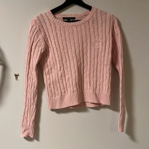 Rosa stickad tröja från Classified - Säljer en superfin rosa stickad tröja från Classified i storlek XS. Den har ett snyggt kabelstickat mönster och är perfekt för både höst och vår. Tröjan är långärmad och har ribbade kanter vid ärmslut och nederkant. Perfekt för att hålla sig varm och stilren! 💖inga defekter💕