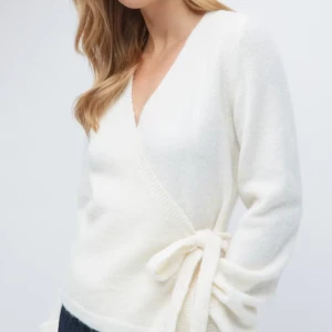 Omlott kofta - Säljer en stilren vit omlott kofta med knytning i sidan. Tröjan har en v-ringad design och långa ärmar, perfekt för en elegant look. Passar bra till både jeans och kjol💖💖💖