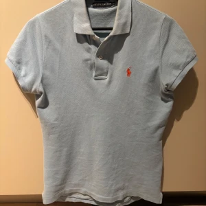 Ljusblå pikétröja från Ralph Lauren - Säljer en stilren ljusblå pikétröja från Ralph Lauren. Den är i väldigt fint skick och använd sällan. Den har krympt i storleken och sitter som xs sitter bra på mig som är 164 men sitter oxå bra på min vän som är 172. Hör av er vid intresse.