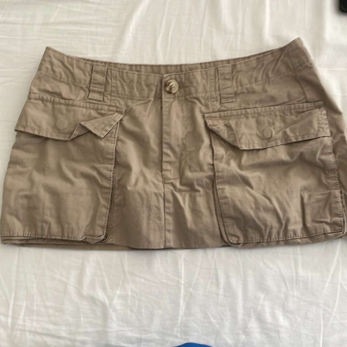 Beige kortkjol med fickor