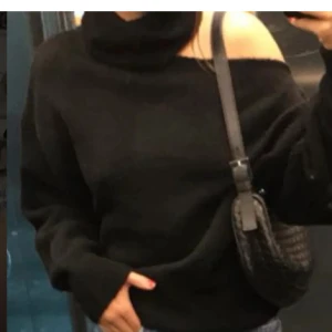 Svart offshoulder tröja - Snygg svart offshoulder tröja med lång ärm. Perfekt för en stilren look och kan matchas med olika accessoarer. Tröjan har en lös passform som ger en avslappnad känsla.