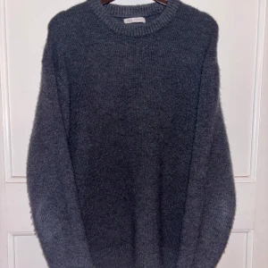Grå stickad tröja från Zara - Skön grå stickad tröja från Zara. Perfekt för kyligare dagar med sin mjuka och varma känsla. Lite nopprig men inte så farligt. Hör av dig om du har frågor.