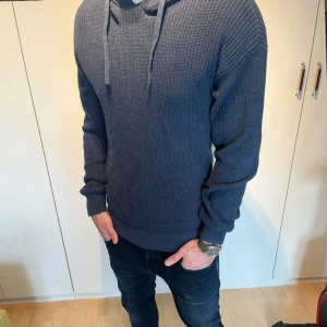 Mörkblå stickad hoodie - Säljer en snygg mörkblå stickad hoodie med långa ärmar och justerbar huva. Storlek S. Modellen är 183. Tveka inte att skriva vid minsta fundering.⭐️