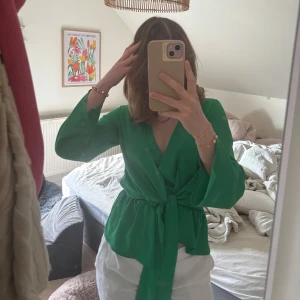 Grön omlott blus  - Säljer denna otroliga gröna omlott blus med fin knytdetalj. Även öppna lösare ärmar som ger en mer avslappnad look.💚 Passae xs-s.