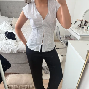 Randig blus från Weekday - Säljer ”Alec Top”  från Weekday. Blusen har en v-ringad design med knappar framtill och korta ärmar. Nypris: 400kr.❤️