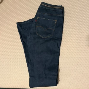 Blå jeans från Levis - Snygga blå jeans från Levis med klassisk femficksdesign och dragkedja. Jeansen köpte jag på secondhand och passa tyvärr inte mig, jättefina annars