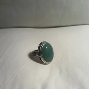 Ring med grön sten (aventurin) - Maffig stor oval grön sten-ring i en detaljerad silverram. Vintage men i bra skick! . Perfekt för att ge en färgklick till din outfit.
