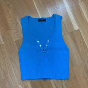 Blå ribbad linnetopp från Dilvin - Snygg blå ribbad linnetopp från Dilvin med knappar framtill. Perfekt för en stilren look. Tillverkad i Turkiet.