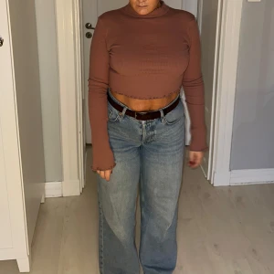 Gammelrosa ribbad croppad tröja från NA-KD - Säljer en gammelrosa ribbad croppad tröja från NA-KD. Tröjan har långa ärmar och en fin volangdetalj vid halsen och nederkanten. Perfekt för en trendig look! 🌟