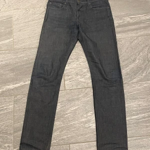 Mörkblå jeans från NN07 - Snygga mörkblå jeans från NN07 med klassisk femficksdesign och knappgylf. Perfekta för en stilren look. Midjan är normalhög och passformen är straight, vilket ger en tidlös stil.