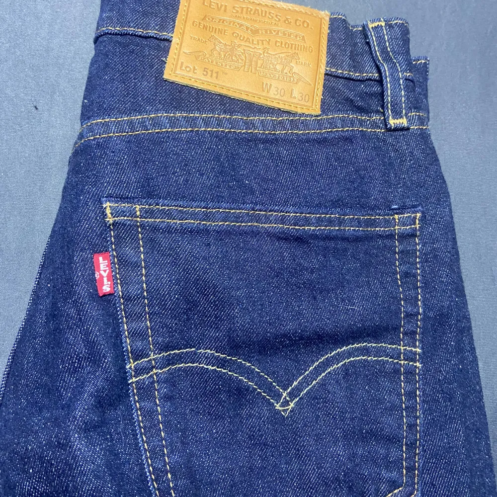 Snygga Levis 511 jeans i mörkblå denim. Klassisk femficksdesign med dragkedja och knapp Märkeslappen i läder baktill. Farkut & Housut.