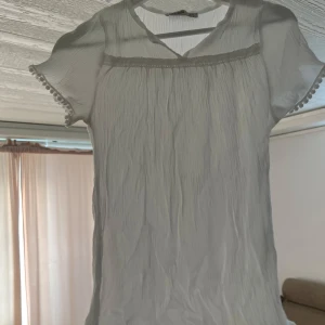 Vit blus från Fullamoda - Säljer en söt vit blus från Fullamoda med korta ärmar och fina spetsdetaljer vid ärmslut och hals. Blusen är helt oanvänd.