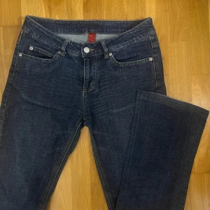 Mörkblå jeans från Vila  - Snygga mörkblå lågmidjade jeans från Vila Clothes. Jeansen är bootcut.  De har dekorativa sömmar på bakfickorna. De sitter bra överallt men något korta. pris kan diskuteras.  