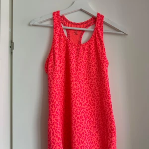 Rosa leopardmönstrad linnetopp från H&M - Säljer en rosa leopardmönstrad linnetopp från H&M Sport. Perfekt för träning med sin ärmlösa design och bekväma passform. Tillverkad i ett lätt och andningsbart material.