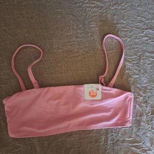 Rosa bikiniöverdel från Bik Bok - Snygg rosa bikiniöverdel från Bik Bok i bandeau-stil med justerbara axelband. Perfekt för soliga dagar på stranden eller vid poolen. Enkel och stilren design som passar till det mesta. 💖