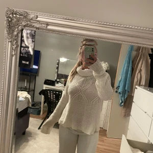 Vit stickad tröja från 157 - Mysig vit stickad tröja från 157 med ett snyggt mönster framtill. Tröjan har långa ärmar och en bekväm passform, perfekt för kyligare dagar. Den är både stilren och enkel att matcha med olika outfits.