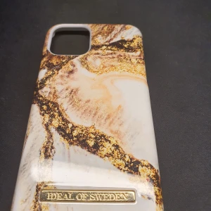 Iphone 11 pro Mobilskal från iDeal of Sweden - Snyggt mobilskal från iDeal of Sweden med ett marmorerat mönster i guld och beige. Skalet har en elegant design och är perfekt för att ge din telefon ett stilrent utseende. Passar utmärkt för den som vill ha både skydd och stil.