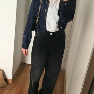 Mörkblå skjorta från Zara - Snygg mörkblå skjorta från Zara med klassisk krage och knappar framtill. Skjortan har långa ärmar och två bröstfickor som ger en stilren look. Perfekt för att höja din outfit till nästa nivå.