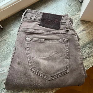 Bruna jeans från Jacob Cohen 688 - Snygga bruna jeans från Jacob Cohen med klassisk femficksdesign och knappgylf. De har en stilren look med en diskret logga på bakfickan. Perfekta för en avslappnad men stilren outfit. Modellen är 688, nypris runt 5000kr. Storlek 30, frågor i DM. 
