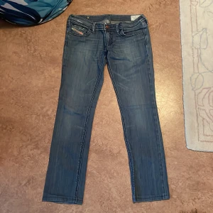 Lågmidjade Diesel jeans  - Säljer ett par Diesel jeans med låg midja och storlek W 29 L 34. Jeansen är väl använda men fortfarande i bra skick. Det har några små slitningar vilket man kan se på bilderna. 