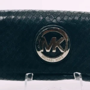 Svart plånbok från Michael Kors - Snygg svart plånbok från Michael Kors med ett elegant ormskinnsmönster. Plånboken har en stor logotyp i metall på framsidan och flera fack inuti för kort och kontanter. Perfekt för att hålla ordning på dina värdesaker med stil.