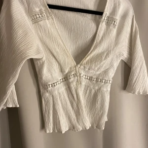 Vit blus från Zara - Säljer en söt vit blus från Zara med v-ringning och knappar framtill. Säljer då den ör för liten för mig.