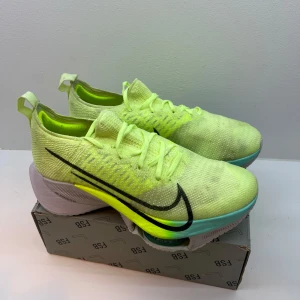 Nike löparskor  - Använda en gång.  Nike löparskor  neongul färg med svart swoosh-logga. Skorna har en avancerad sula med Air Zoom-teknologi för extra dämpning och komfort. Perfekta för löpning båda kortdistans och långdistans.  Väldigt slittålig sula. 