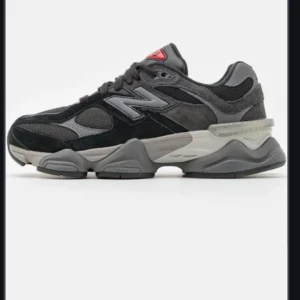Svarta sneakers från New Balance - Snygga svarta sneakers från New Balance med grå och röda detaljer. Skorna har en robust sula och klassisk snörning. Perfekta för en sportig look.  Svåra att få tag på. Helt nya aldrig använda pris 2000