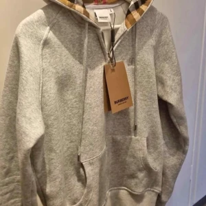 Grå hoodie från Burberry - Säljer för den inte passar mig. Ny och oanvänd. Storleken är M men den är mer som en S. 