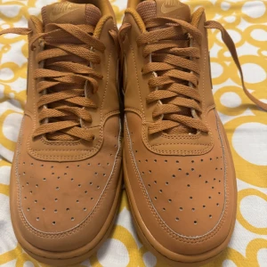 Bruna Nike sneakers - Snygga bruna Nike sneakers med klassisk design och snörning. Skorna har en perforerad tå för ventilation och en robust sula för bra grepp. Perfekta för en avslappnad stil.