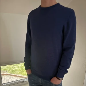 Blå merinoull tröja - Säljer en stilren blå tröja från These Glory Days i Superior Merino. Den är mjuk och bekväm, idealisk för både vardag och mer uppklädda tillfällen | Storlek: M | Skicket på tröjan är väldigt bra utan några defekter alls (använd en gång) - Pris: 350 - Nypris: 999kr - Skriv vid funderingar!