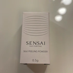 Sensai Silky Purifying Silk Peeling Powder - Upptäck Sensai Silky Purifying Silk Peeling Powder, en lyxig peeling i pulverform som förvandlas till ett silkeslent skum vid kontakt med vatten. Perfekt för att varsamt exfoliera och rengöra huden. Kommer i en smidig liten flaska på 0,5g, idealisk för resor eller att testa produkten.