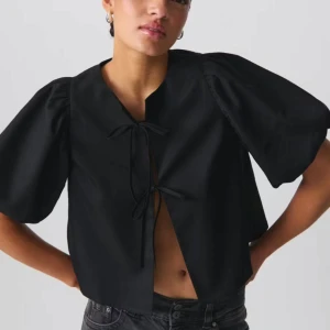 Svart blus med puffärmar - Säljer min fina blus från Gina som aldrig kommer till användning då jag har en till likadan. Den är super fin att styla med en svart tight långklänning under på sommarn eller jeans/kostymbyxor! Jag är en S men har L i dessa för jag tycker dom sitter finare som oversize. 