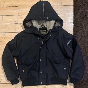 Svart jacka med pälsfoder från Woolrich - Helt sjukt snygg och ganska sällsynt bomber jacka från Woolrich. Storlek S men passar som en M.  Perfekt till vintern.  Då denna modell ej säljs längre vet jag ej nypris exakt men Woolrich vinterjackor ligger på runt 400-700€. Jag köpte denna för många många år sedan från Tori Bra alternativ för en Canada Goose jacka 🤘  Fraktar spårbart eller möts upp i Kampen