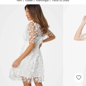 Vit blommig klänning - Säljer en vacker vit klänning med blommiga detaljer och v-ringning. Klänningen har korta ärmar och en luftig passform, perfekt för sommarens festligheter. Den är tillverkad i ett lätt och bekvämt material som ger en romantisk känsla. Perfekt för dig som vill sticka ut med stil! 🌸Köpt inför student men ej använts.