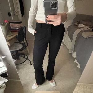 Svarta kostym byxor - Snygga svarta kostym byxor med en stilren design. De har en medel hög/låg midja och en rak/bootcut passform. Perfekta för en fest eller vardags outfit. Storlek 32/34 och längden vet jag tyvärr inte men jag är 165 cm lång. 💘för mer bilder eller frågor, skriv privat.