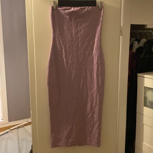 Lila glittrig axelbandslös klänning - Snygg lila långkjol med glittrigt material och en slits baktill. Passar storlek S, M. Pris kan diskuteras!