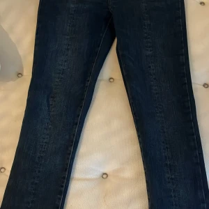 Mörkblå jeans med slits från TOMORROW - Snygga mörkblå jeans med slits vid anklarna. Klassisk femficksdesign och en stilren look som passar perfekt till vardags. Jeansen har en tight passform och är tillverkade i ett bekvämt denimtyg. W27