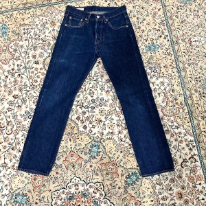 Levis 501 jeans i mörkblå denim - Säljer ett par klassiska Levis 501 jeans i mörkblå denim. De har en rak passform och är lågmidjade med den ikoniska Levis-lappen baktill. Perfekta för en tidlös stil. Knappast använda. nypris går för 1299