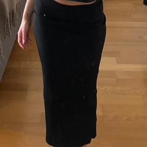 Svart midikjol från Monki - Snygg svart ribbad långkjol från Monki. Kjolen har en tight passform, ett mjukt och stretchigt material. Använd enstaka gång så fortfarande i nyskick. Nypris 400kr.