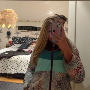 Färgglad skidjacka - Säljer en unik och färgglad jacka med prickigt mönster i olika färger. Jackan har en dragkedja framtill och är Perfekt för att liva upp garderoben!