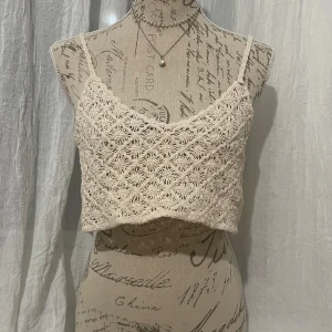 Beige virkad linnetopp - Beige virkad linnetopp med smala axelband och ett vackert mönster. Finns också i vit färg (kolla på min andra annonser).