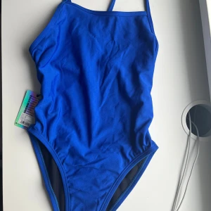 Perry swim onesie Jolyn blueberry  - Helt oandvänd jolyn baddräkt i modellen Perry swim onesie i färgen blueberry. Storlek 28.  Endast testad med kläder under. Fick i present men gick inte att skicka tillbaka . Där av skulle jag vilja byta mot samma modell och färg men i storlek 30 helst i nyskick, annars beroende på skick betala men en mindre summa. Eftersom den är oandvänd skulle jag kunna tänka mig att sälja den för runt 750-800 kr. Nypris:871. Köpare står för frakt. Kan mötas upp i Stockholm. Skriv vid frågor eller innan köp.😊💗