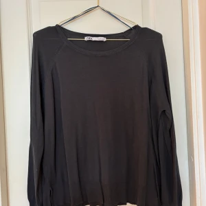 Svart tunnstickad tröja från Zara - Säljer en stilren grå/blå tunnstickad tröja från Zara. Tröjan har en rund halsringning och är tillverkad i ett mjukt material som ger en bekväm passform. Perfekt för en avslappnad look. Lite liten i storlek så skulle passa M. 