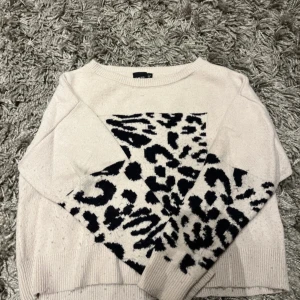 Tröja med leopardmönster från LMTD - Säljer en beige tröja från LMTD med svart leopardmönster. Tröjan har ribbade muddar vid ärmslut och nederkant. Perfekt för en trendig look!