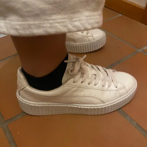 Vita sneakers med platåsula - Snygga vita sneakers med en hög platåsula och klassisk snörning. Skorna har en stilren design med en glansig finish som ger en modern touch. Perfekta för att lyfta din vardagslook.