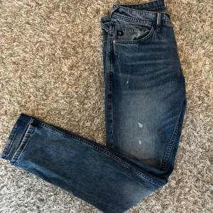 Tom T. Jeans med slitningar - Snygga blå jeans från Tom Tailor med en klassisk femficksdesign. De har en lätt slitning på framsidan som ger en trendig look. Perfekta för en avslappnad stil. Waist: 30 Längd: 32