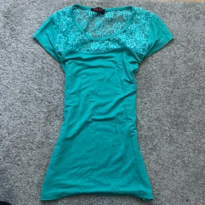 T-shirt - Blå/turkos T-shirt, med genomskinlig spetsblom detaljer längst upp🫶🏼 storlek: xs💕 kom privat  för frågor💕