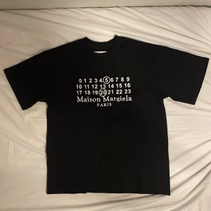 Maison Margiela T-shirt - Svart t-shirt från Maison Margiela med deras ikoniska siffertryck på framsidan i storlek M. Helt nytt skick och endast prövad på en gång. Hör av er vid eventuella byten eller frågor!